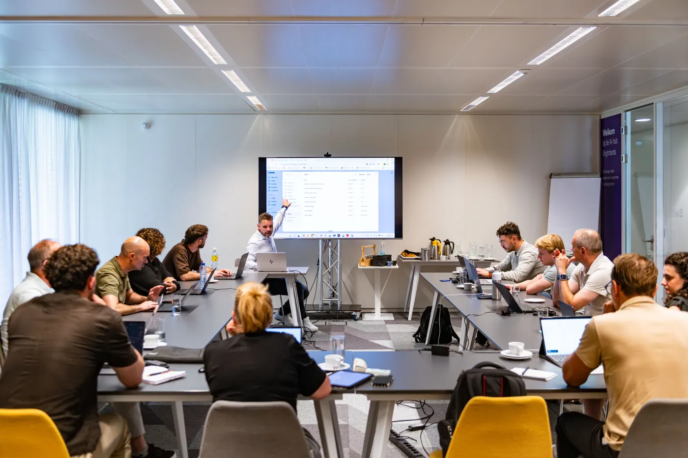 Deelnemers werken naast elkaar op hun eigen laptop tijdens een training
